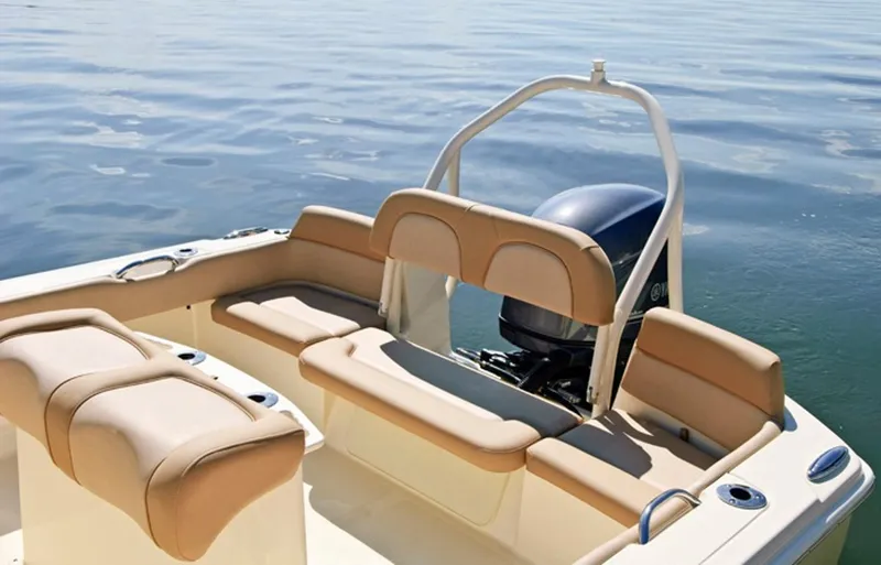 Slide: The Image of Manufacturer Provided Image: 2014 Scout 195 Sportfish boat with tan seating and outboard motor on calm water. - 13