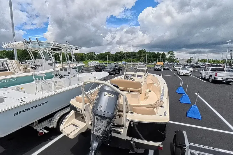 Slide: The Image of 2014 Scout 195 Sportfish boat in parking lot, surrounded by cars and cloudy sky. - 5