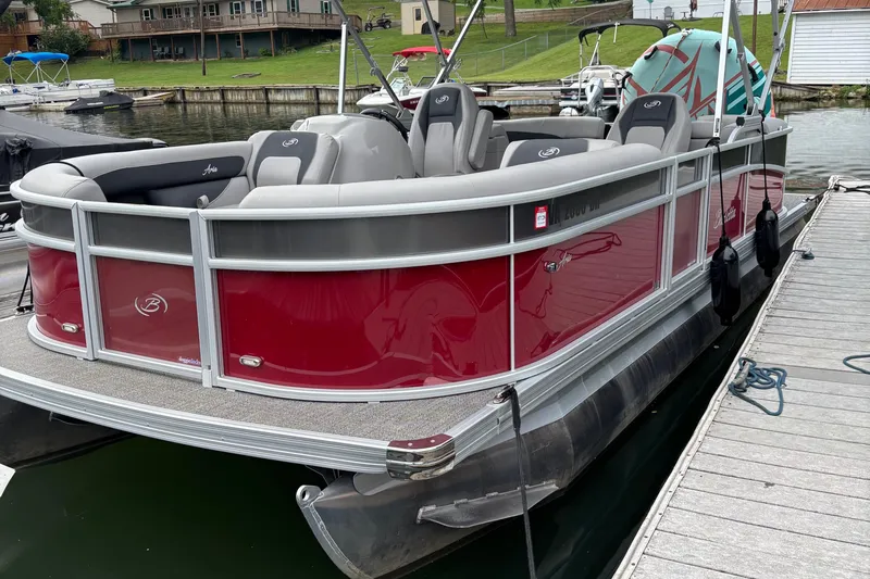 The Image of 2025 Barletta ARIA 22QC pontoon boat docked, featuring red and gray design. - 0
