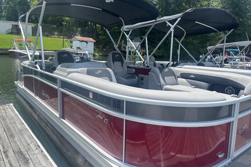 Slide: The Image of 2025 Barletta ARIA 22QC pontoon boat docked, featuring sleek design and spacious seating. - 2