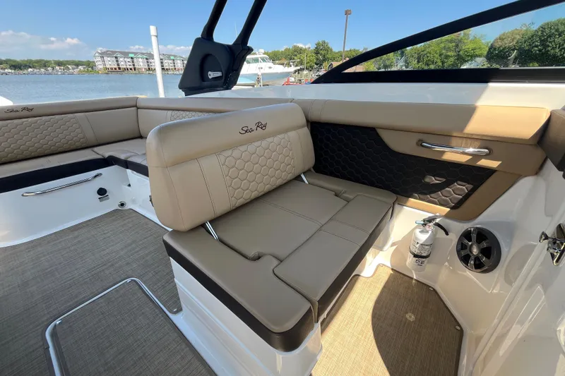 Slide: The Image of 2021 Sea Ray SDX 270 Outboard interior with tan seating and lake view. - 10