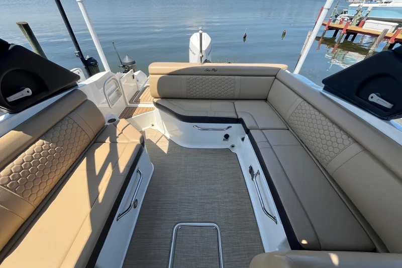 Slide: The Image of 2021 Sea Ray SDX 270 Outboard interior with beige seating and waterfront view. - 12