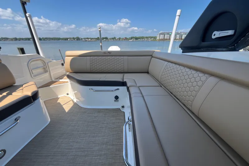 Slide: The Image of 2021 Sea Ray SDX 270 Outboard boat interior with beige seating and lake view. - 14