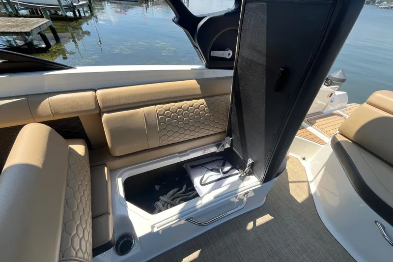 Slide: The Image of 2021 Sea Ray SDX 270 Outboard boat with open storage compartment and beige seating. - 17