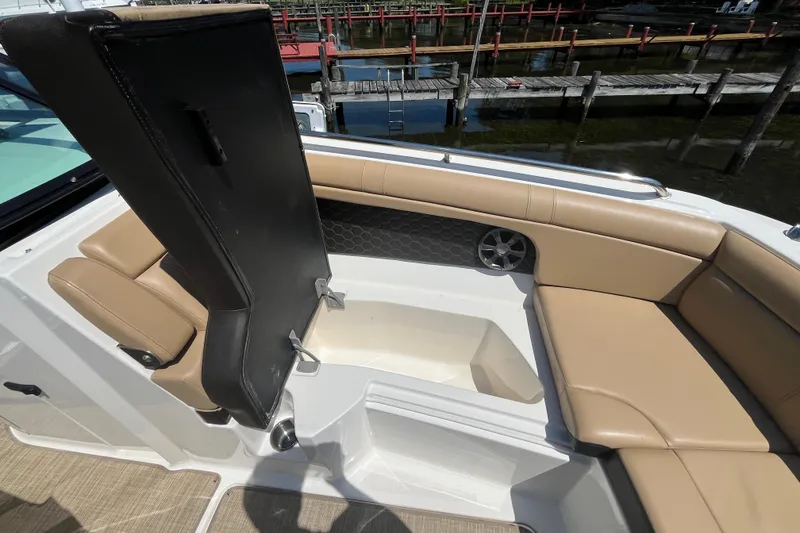 Slide: The Image of 2021 Sea Ray SDX 270 Outboard interior with tan seating and storage compartment. - 21
