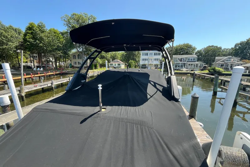Slide: The Image of 2021 Sea Ray SDX 270 Outboard covered at a dock, surrounded by waterfront homes. - 28