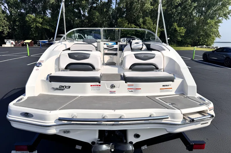 Slide: The Image of 2019 Chaparral Vortex 203 VRX boat, rear view, parked on asphalt with trees in background. - 5