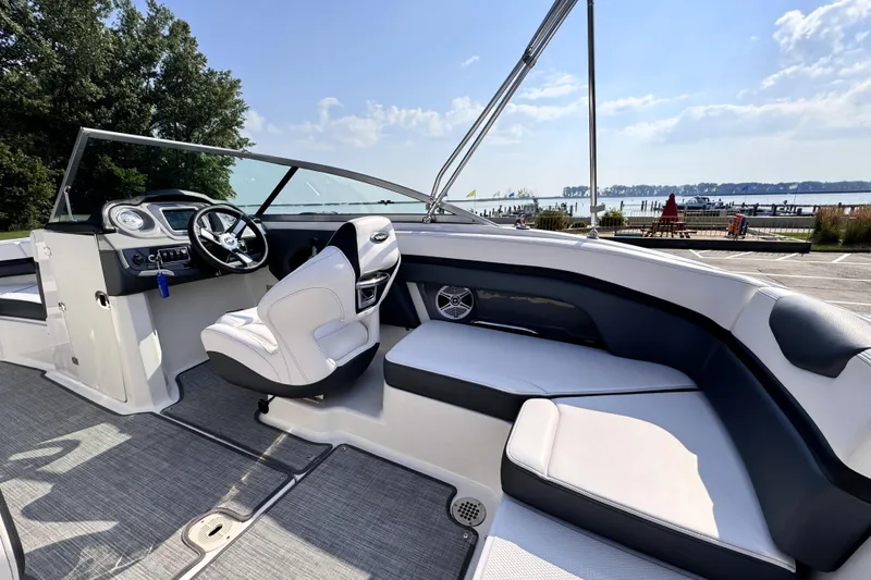 Slide: The Image of 2019 Chaparral Vortex 203 VRX boat interior with steering wheel and seating, dockside view. - 6