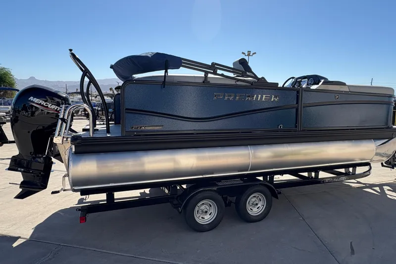 Slide: The Image of 2026 Premier 210 Sunsation RF pontoon boat on trailer, featuring Mercury outboard motor. - 3
