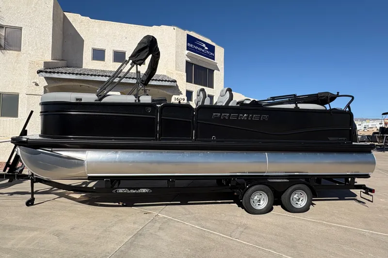 The Image of 2026 Premier 230 SunSation RF pontoon boat on trailer, parked outside a building. - 0
