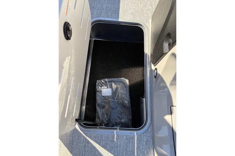 Slide: The Image of Storage compartment in 2026 Premier 230 SunSation RF boat, featuring carpeted interior. - 15