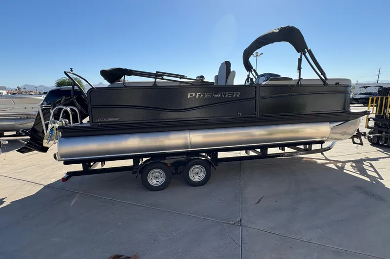 Slide: The Image of 2026 Premier 230 SunSation RF pontoon boat on trailer, parked outdoors. - 4