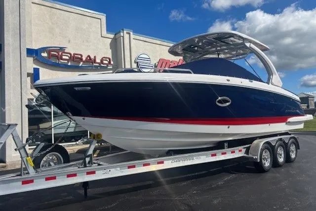 Slide: The Image of 2023 Chaparral 307 SSX boat on trailer, displayed outside dealership under blue sky. - 2