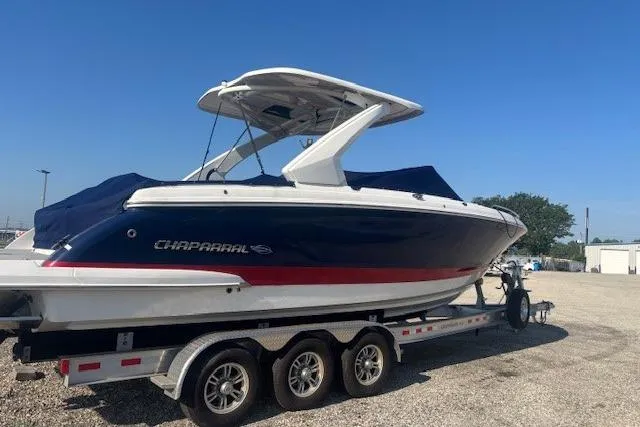 Slide: The Image of 2023 Chaparral 307 SSX boat on trailer, blue and white design, parked outdoors. - 27