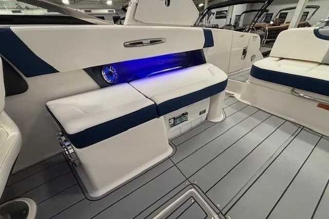 Slide: The Image of 2023 Chaparral 307 SSX boat interior with blue LED lighting and cushioned seating. - 33