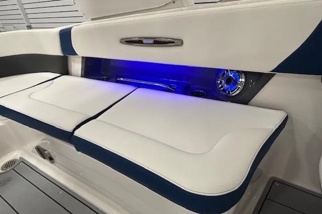 Slide: The Image of 2023 Chaparral 307 SSX boat interior with white seating and blue LED lighting. - 34