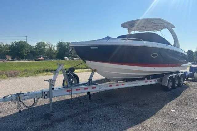 Slide: The Image of 2023 Chaparral 307 SSX boat on a trailer, parked outdoors under clear skies. - 35