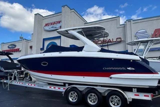 Slide: The Image of 2023 Chaparral 307 SSX boat on trailer, displayed at dealership with clear sky background. - 38