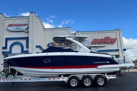 Slide: The Image of 2023 Chaparral 307 SSX boat on a trailer outside a dealership under a blue sky. - 39