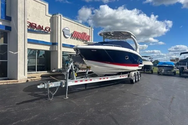 Slide: The Image of 2023 Chaparral 307 SSX boat on trailer outside dealership under blue sky. - 40