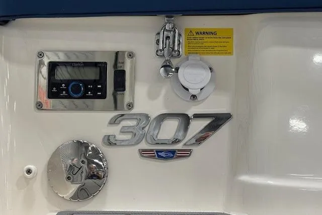 Slide: The Image of 2023 Chaparral 307 SSX boat dashboard with control panel and warning label. - 51