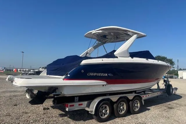 Slide: The Image of 2023 Chaparral 307 SSX boat on a trailer, blue and white design, parked outdoors. - 6