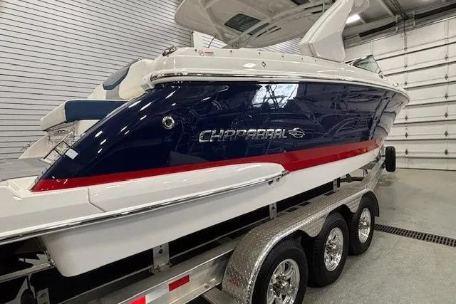 Slide: The Image of 2023 Chaparral 307 SSX boat on trailer in garage setting. - 62