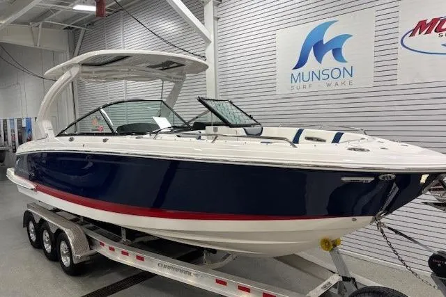 Slide: The Image of 2023 Chaparral 307 SSX boat on trailer in showroom, Munson Surf Wake sign visible. - 66