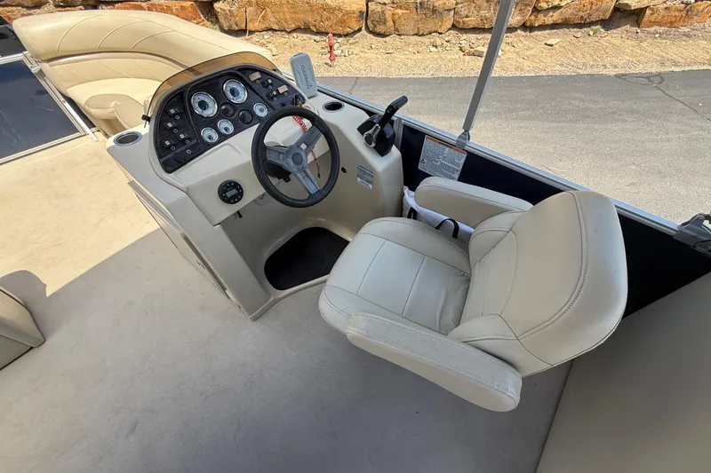 Slide: The Image of 2019 SunChaser Geneva Cruise 22 LR PSB boat interior with steering console and beige seating. - 19