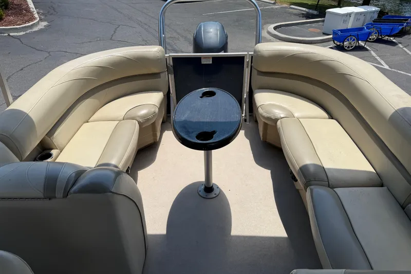 Slide: The Image of 2019 SunChaser Geneva Cruise 22 LR PSB pontoon boat interior with beige seating and table. - 22