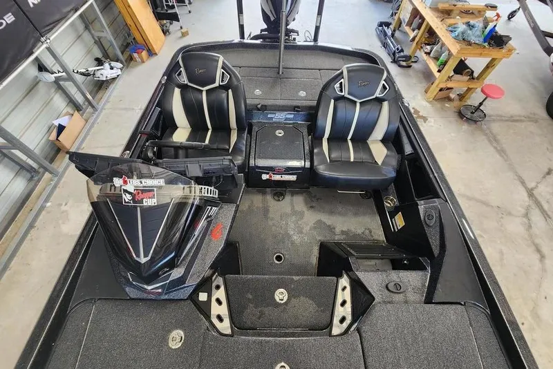 Slide: The Image of 2023 Ranger Z520R boat interior with dual seats and control panel in a workshop. - 8