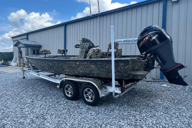 Slide: The Image of 2026 War Eagle 2170 Blackhawk boat on trailer, parked outside a building. - 2