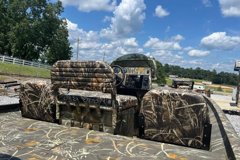 Slide: The Image of 2026 War Eagle 2170 Blackhawk boat with camouflage seating under a clear blue sky. - 8