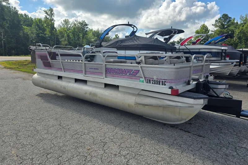 The Image of 1988 Starcraft SD200 pontoon boat parked on asphalt with trees in the background. - 1