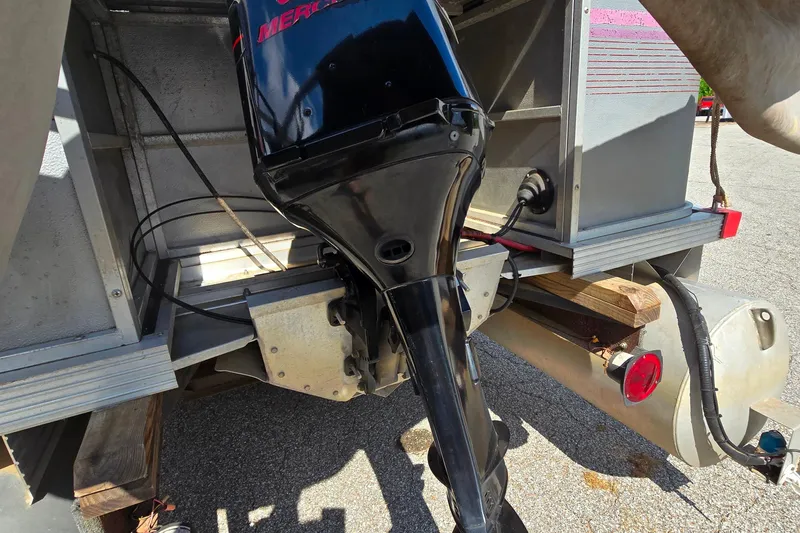 Slide: The Image of Outboard motor on a 1988 Starcraft SD200 boat, parked on pavement. - 10