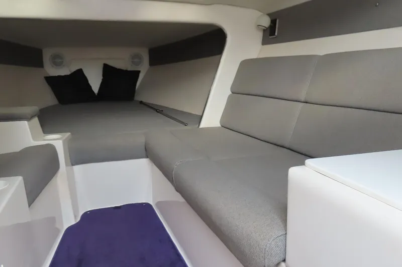 Slide: The Image of Interior of a 1998 Magic 34 Sorcerer boat with gray seating and cushions. - 10