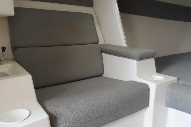 Slide: The Image of Interior seating of 1998 Magic 34 Sorcerer boat with gray upholstery and cup holders. - 12