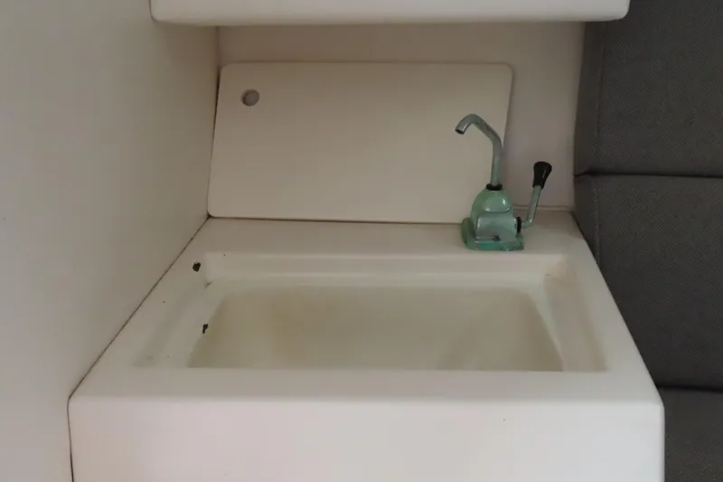 Slide: The Image of Compact sink area in a 1998 Magic 34 Sorcerer boat interior. - 14