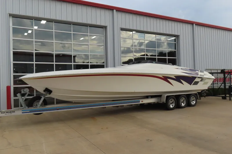 Slide: The Image of 1998 Magic 34 Sorcerer speedboat on trailer, parked outside a garage. - 3