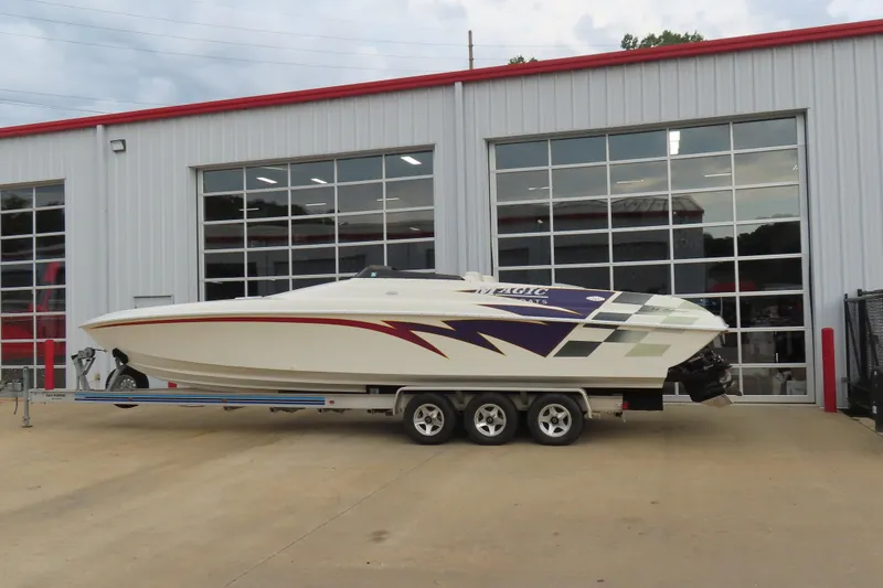 Slide: The Image of 1998 Magic 34 Sorcerer speedboat on trailer, parked outside a garage. - 4