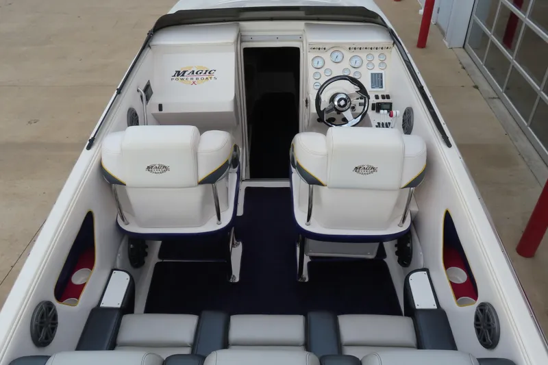 Slide: The Image of 1998 Magic 34 Sorcerer boat interior with white seats and control panel. - 5