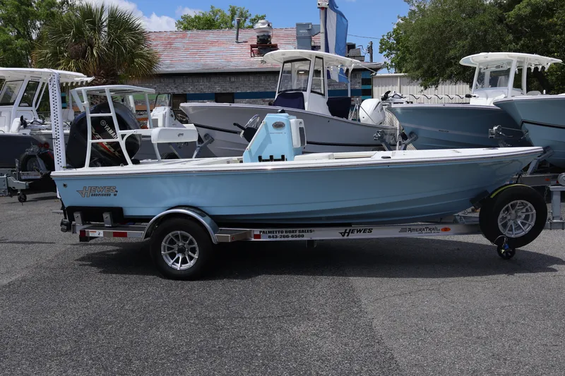 Slide: The Image of 2025 Hewes Redfisher 16 boat on trailer, parked outdoors near other boats. - 7