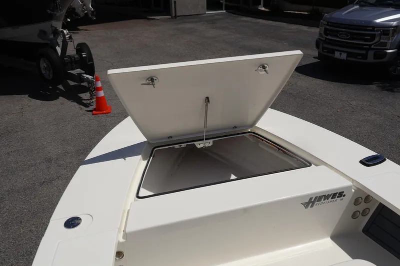 Slide: The Image of 2025 Hewes Redfisher 16 boat with open storage compartment, parked outdoors. - 8
