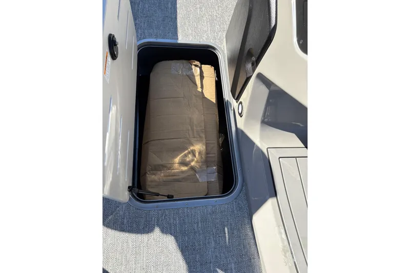 Slide: The Image of Storage compartment in 2026 Premier 230 Sunsation RL boat, featuring a cardboard box. - 10