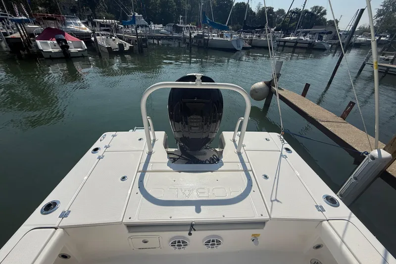 Slide: The Image of 2022 Robalo 226 Cayman boat docked at marina, rear view with motor. - 10