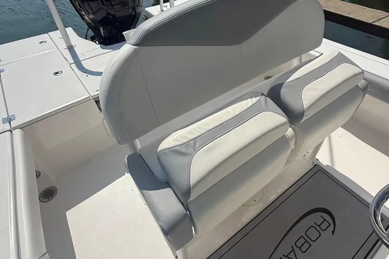 Slide: The Image of 2022 Robalo 226 Cayman boat interior with cushioned seating and deck details. - 11