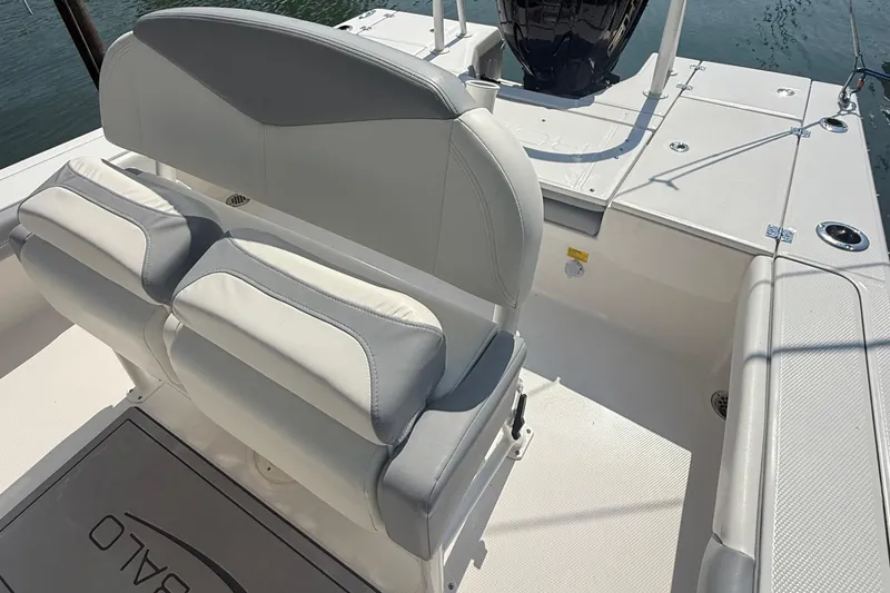Slide: The Image of 2022 Robalo 226 Cayman boat interior with cushioned seating and sleek design. - 12