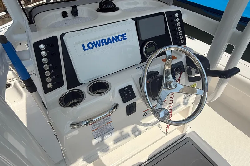 Slide: The Image of 2022 Robalo 226 Cayman boat dashboard with Lowrance navigation system and steering wheel. - 14