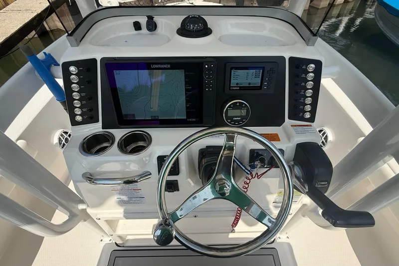 Slide: The Image of 2022 Robalo 226 Cayman boat dashboard with steering wheel and navigation controls. - 16
