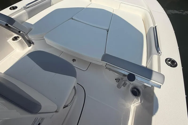 Slide: The Image of 2022 Robalo 226 Cayman boat interior with cushioned seating and stainless steel fixtures. - 20